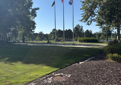 Duplicate Flagpoles with American flag and state flags in landscaped area
